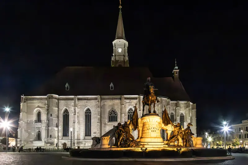 Biserica Sfântul Mihail și statuia lui Matei Corvin, noaptea, în Piața Unirii